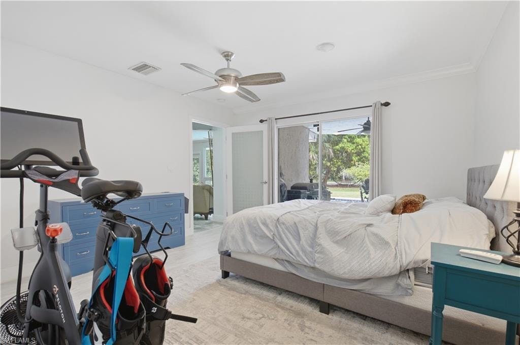 Spacious room featuring light-toned flooring, a ceiling fan, and crown molding