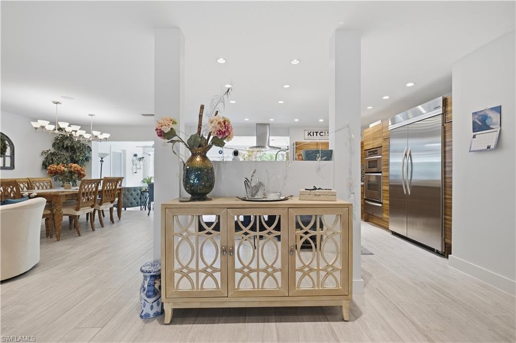 Open-concept interior featuring light wood-finish flooring, recessed lighting, and a neutral color palette