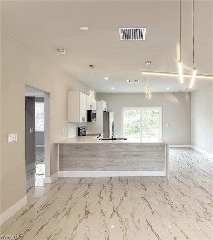 Open-concept kitchen and living area featuring large format marble-look tile flooring