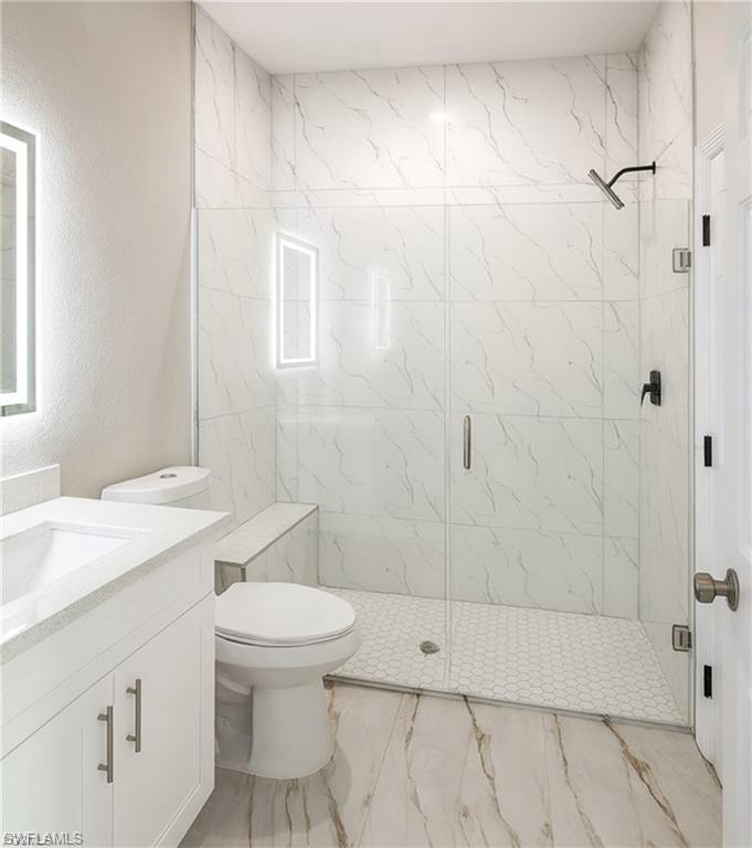 Walk-in shower with clear glass enclosure and a built-in bench
