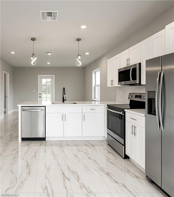 Modern kitchen featuring white cabinetry, stainless steel appliances, a center island with sink, black matte faucet, and large-format tile flooring