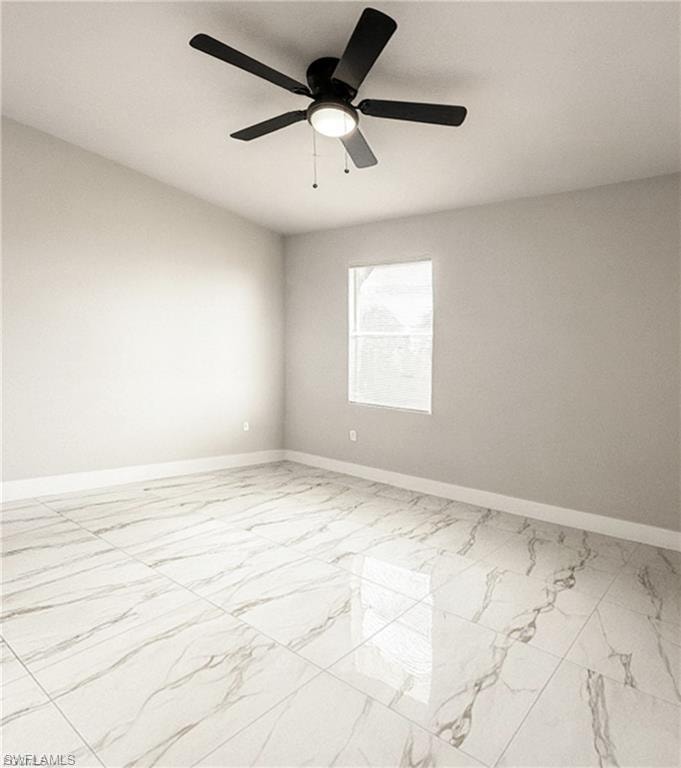 Spacious room featuring large format tile flooring, a mounted ceiling fan with integrated lighting, and a window for natural illumination