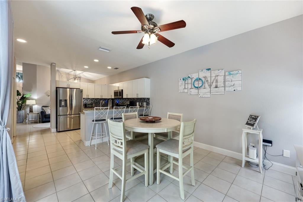Dining room featuring light tile patterned floors, ceiling fan, and recessed lighting