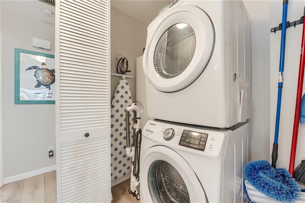 2nd Level Laundry room with wood finished floors and stacked washing machine and dryer- Virtually Edited Image