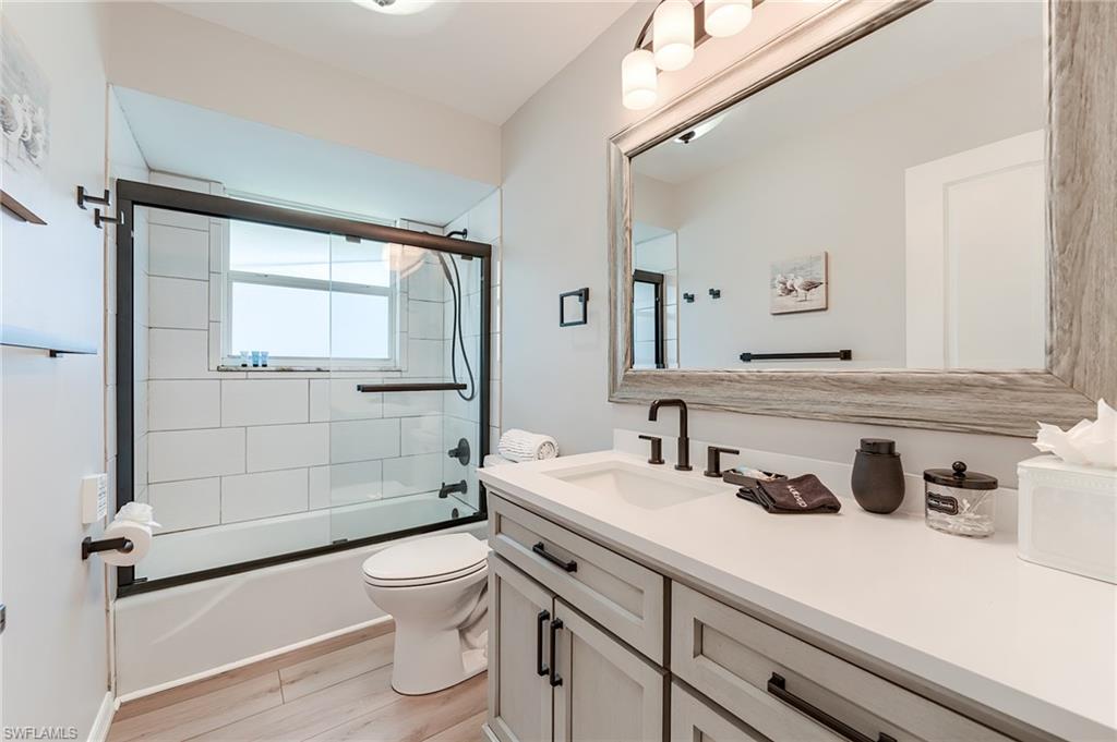 2nd Level Full bathroom with vanity, bath / shower combo with glass door, and light wood finished floors- Virtually Edited Image