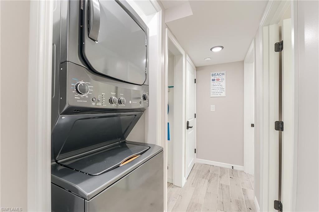 1st Floor Laundry room featuring stacked washer and clothes dryer and light wood-style flooring- Virtually Edited Image