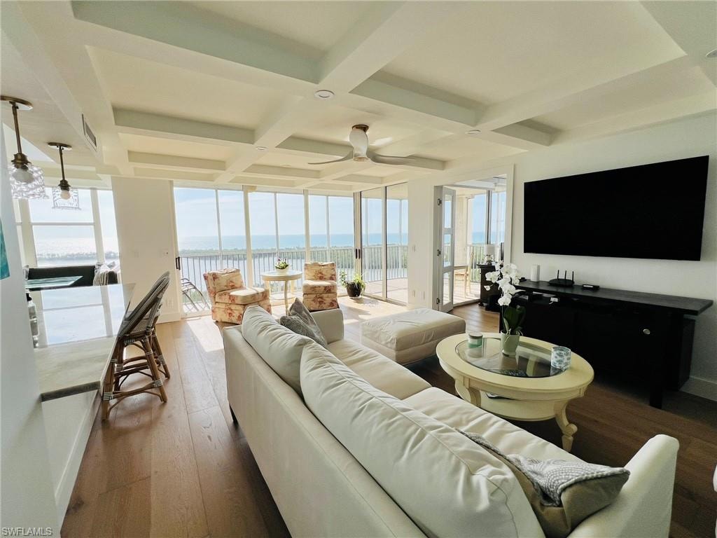Expansive living area with coffered ceilings, wood-finish flooring, and a wall of windows