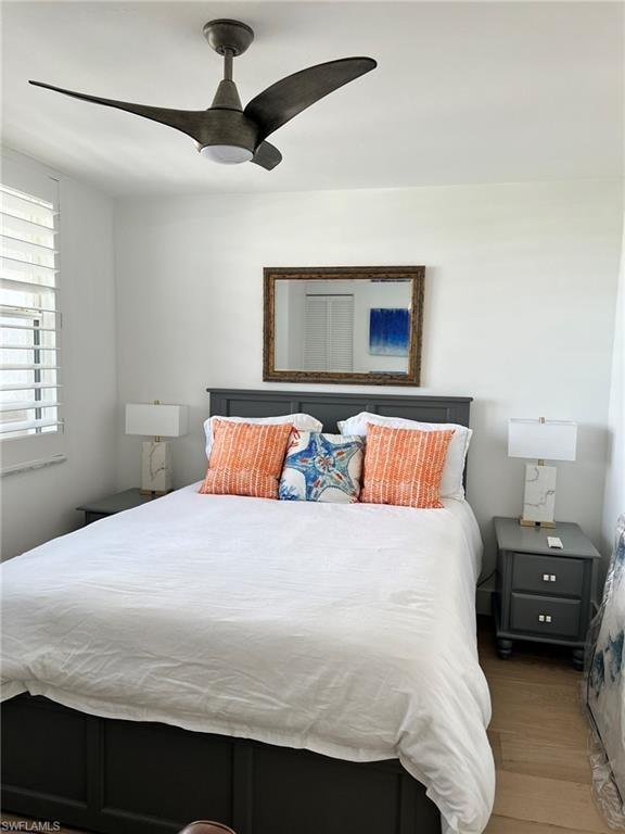 Bright interior space featuring a ceiling fan with integrated lighting, plantation shutters, and wood-finish flooring