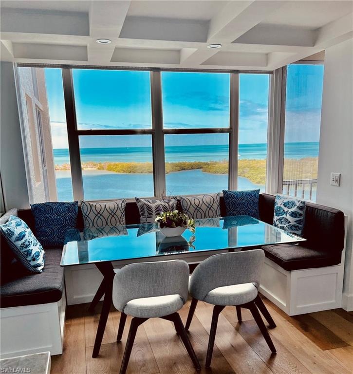 Expansive waterfront windows featuring a coffered ceiling and built-in bench seating with concealed storage