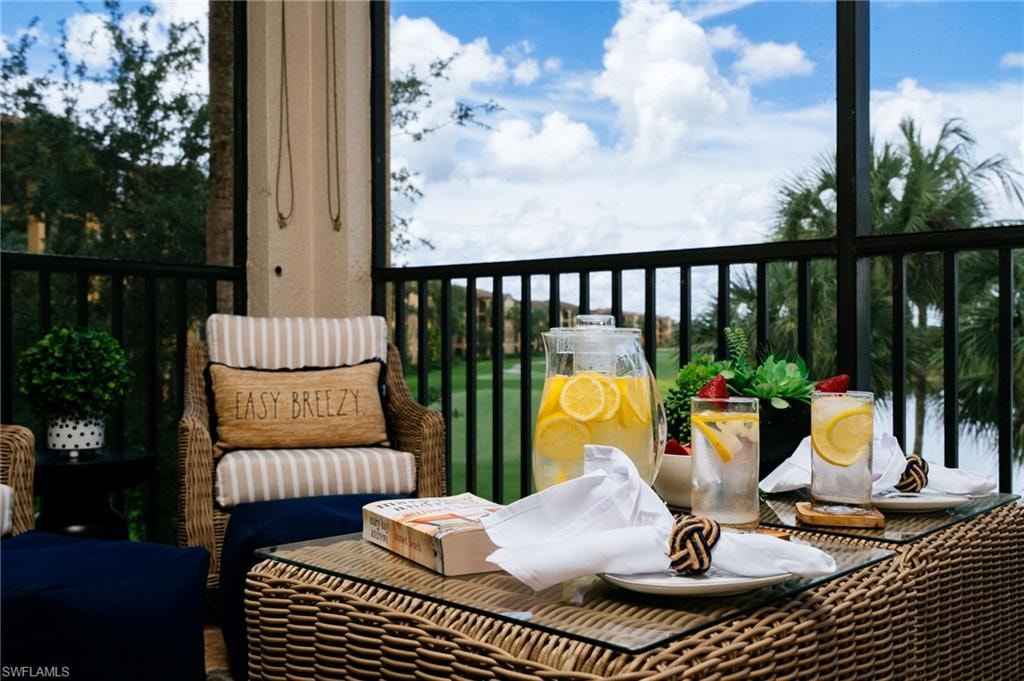 Screened lanai with wicker furniture and golf course view