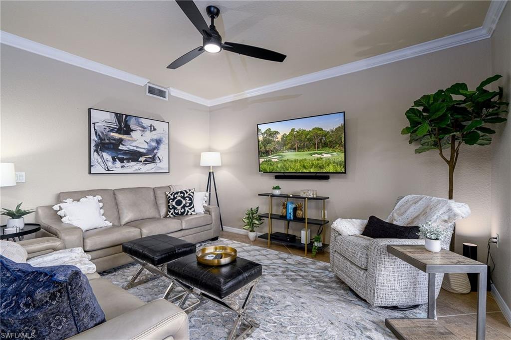 Living area with crown molding, ceiling fan, and light neutral wall paint