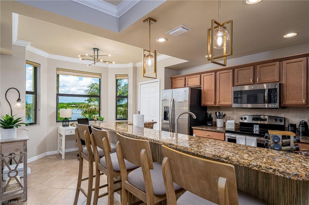Kitchen featuring a tiered ceiling with crown molding, recessed lighting, and modern pendant fixtures