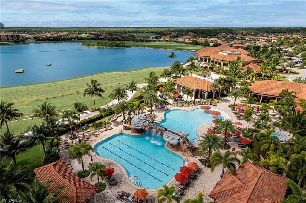 Community resort pool with waterfall feature and lake view