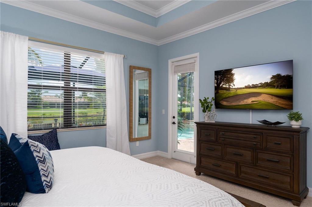 Room featuring a tray ceiling with crown molding, wall-to-wall carpet, and a large window with blinds
