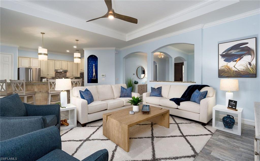 Open-concept living area with tray ceiling and recessed lighting