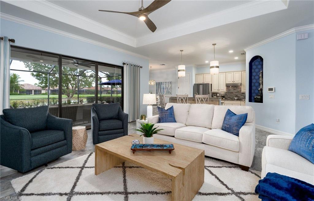 Open-concept living space featuring a tray ceiling with a ceiling fan, recessed lighting, and crown molding