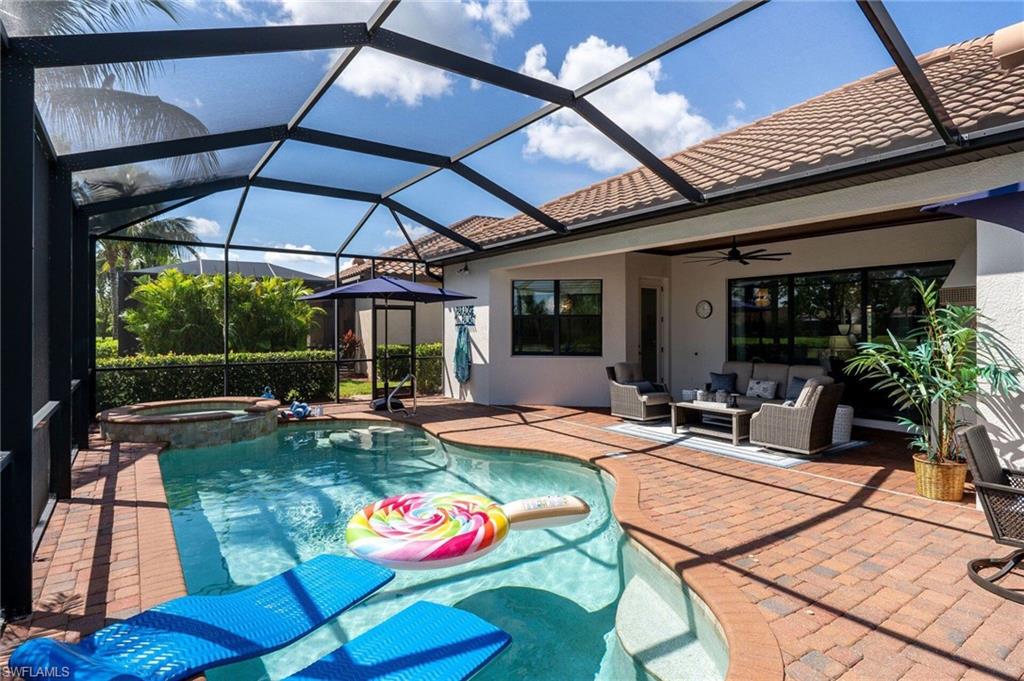 Screened pool and spa area featuring brick paver decking
