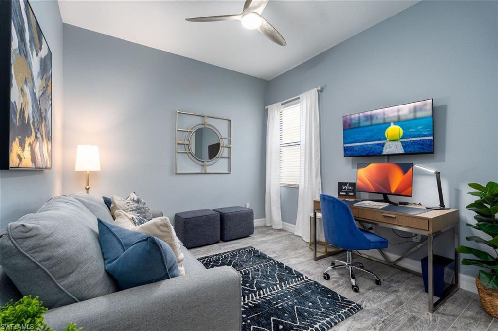 Den featuring queen size sleeper couch, a contemporary ceiling ceiling fan, and a window with blinds and drapes