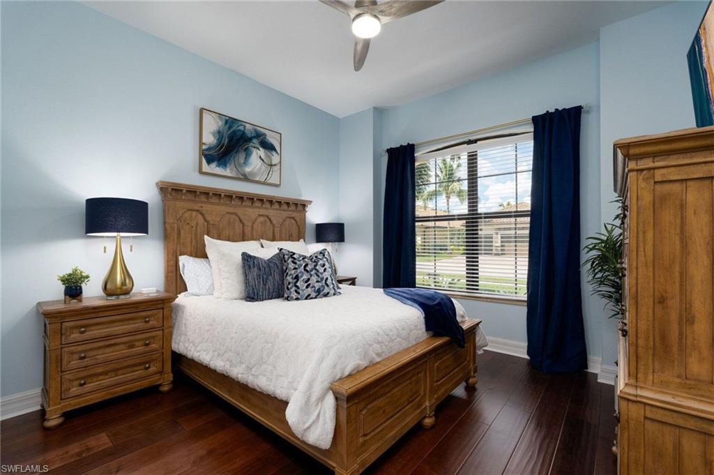 Bedroom featuring wood-finish flooring, a ceiling fan, window with blinds, and light blue walls