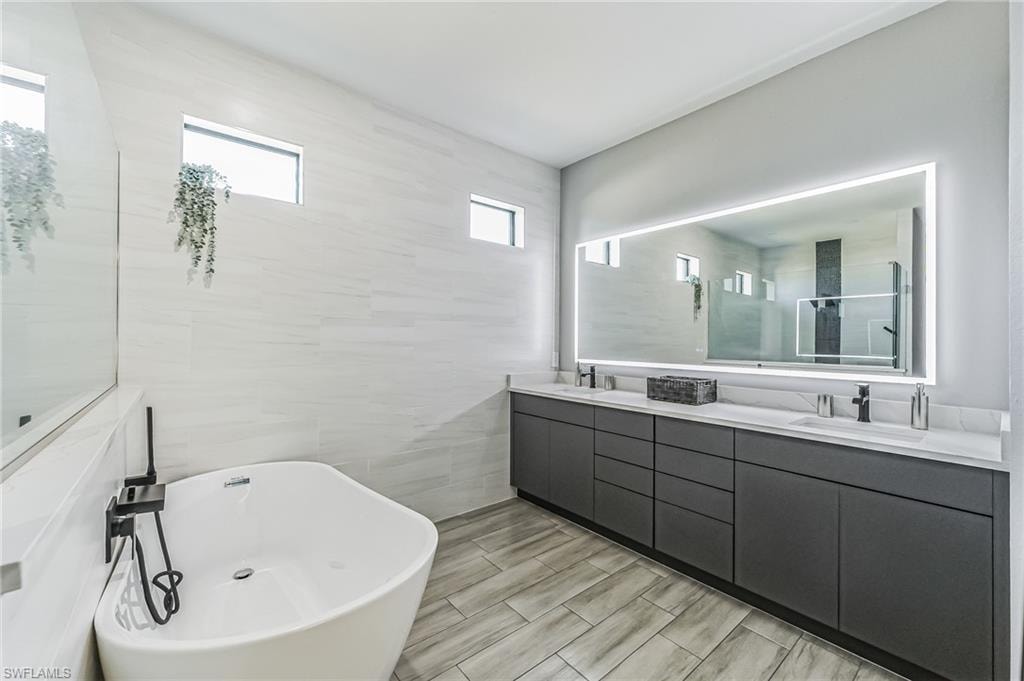 Modern bathroom featuring a freestanding soaking tub and a long double vanity