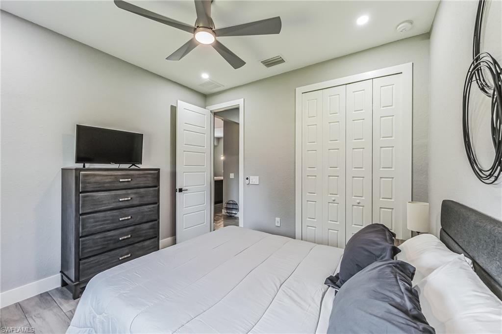 Bedroom featuring wood-finish flooring, recessed lighting, a ceiling fan with integrated lighting, and a bi-fold closet with panel doors