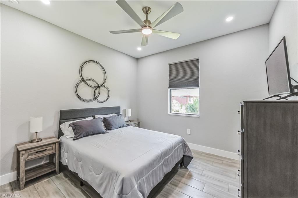 Bedroom featuring wood-finish tile flooring, recessed lighting, and a ceiling fan with integrated lighting