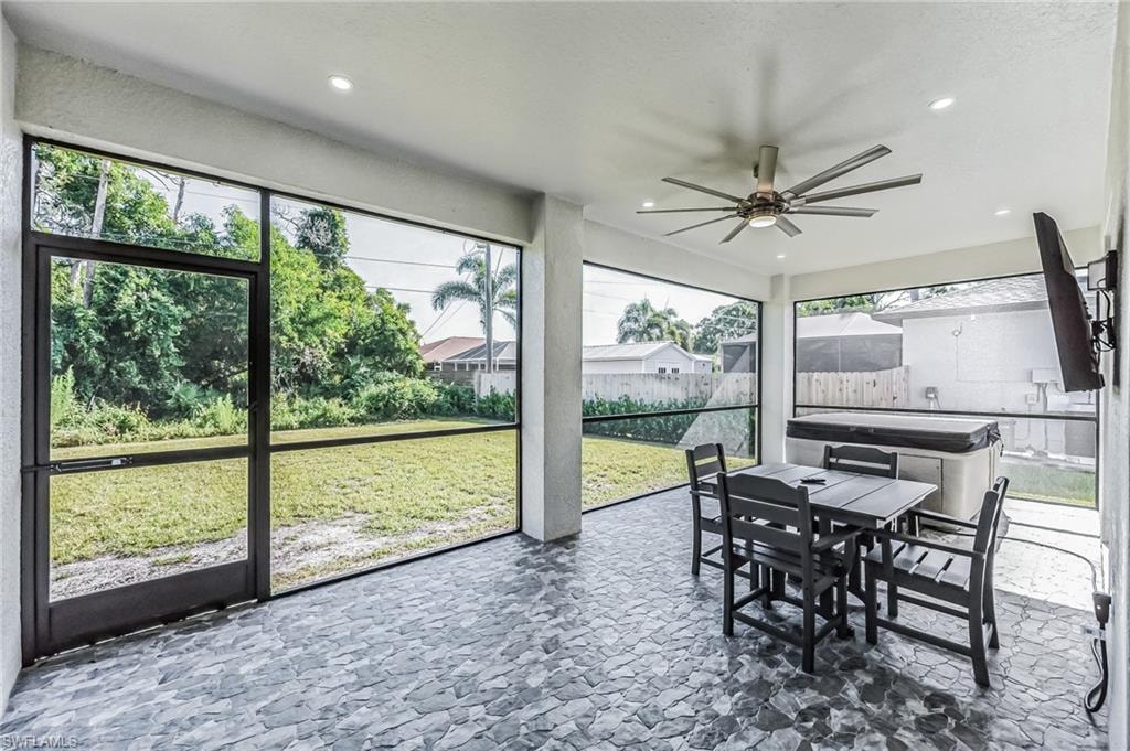 Screened patio featuring stone-look flooring, recessed lighting, and a ceiling fan