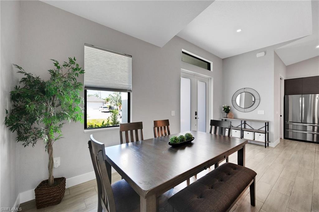 Dining space with wood-finish flooring, recessed lighting, and a window with blinds