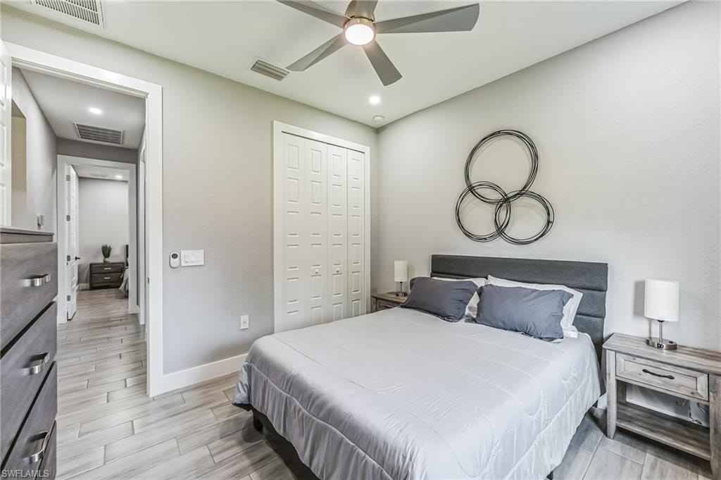 Bedroom featuring wood-look tile flooring, a modern ceiling fan, recessed lighting, and a bi-fold closet door