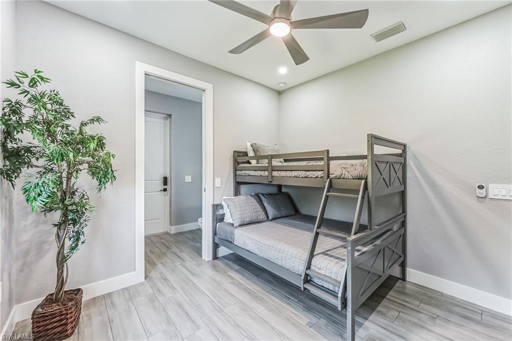 Room featuring wood-finish flooring, a contemporary ceiling fan with integrated lighting, and recessed ceiling lights