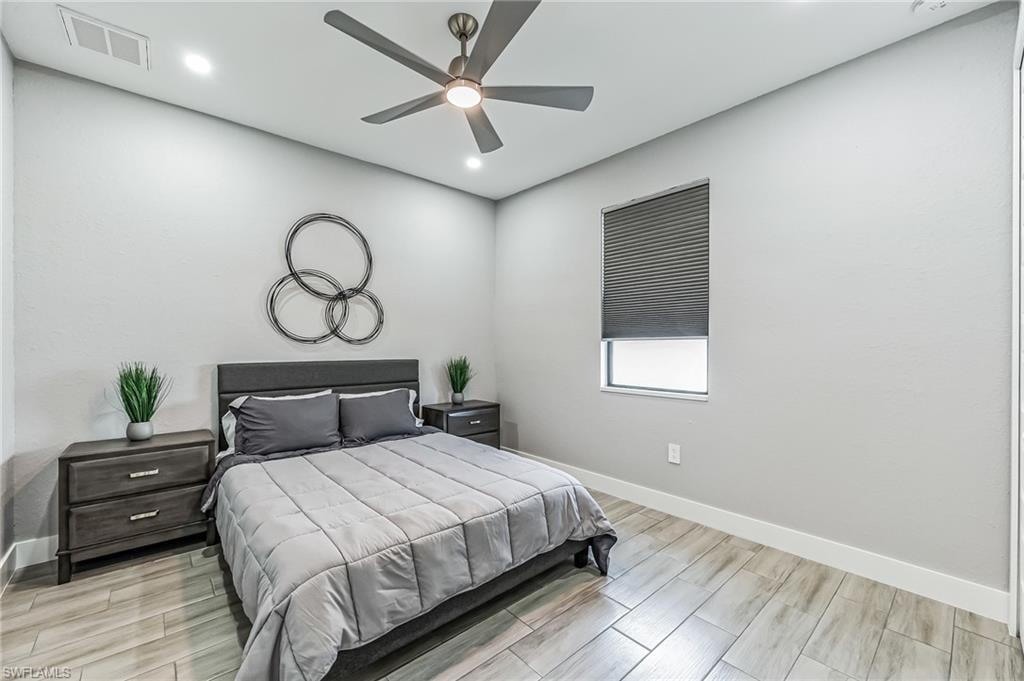 Spacious room featuring wood-finish flooring, recessed lighting, and a ceiling fan
