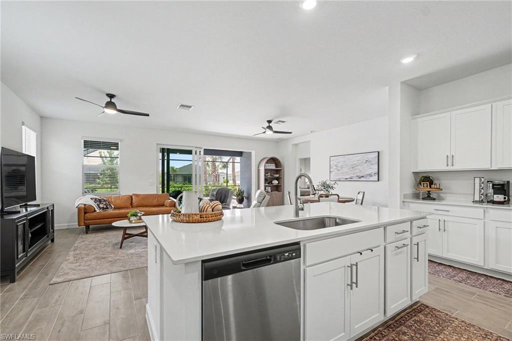 Kitchen island featuring an undermount sink and a stainless steel dishwasher