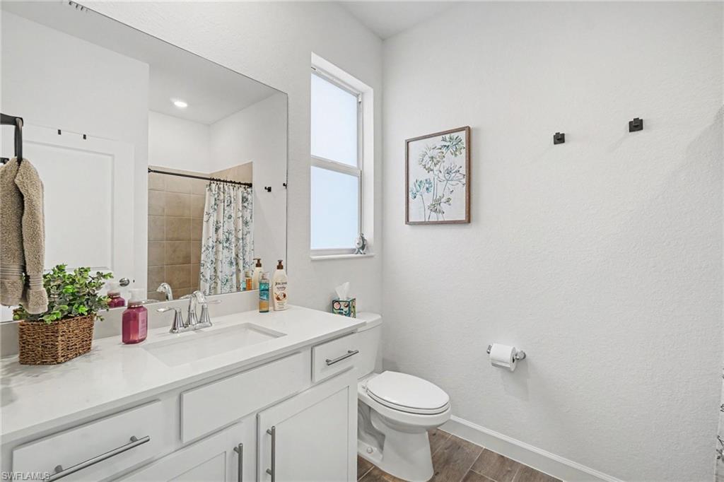 Bathroom featuring a white vanity with an integrated sink, polished chrome faucet, and ample under-sink storage