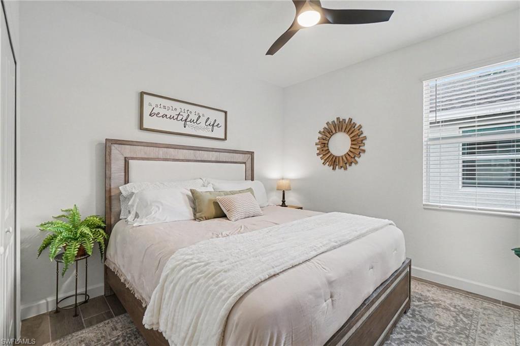 Bedroom featuring a modern ceiling fan, single window with blinds, and wood-finish flooring