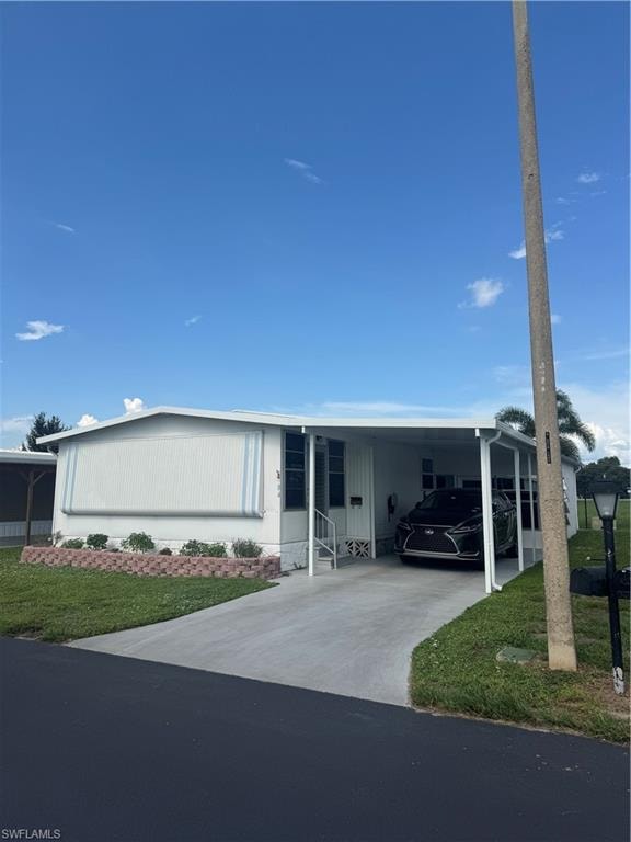 Single-story residence featuring white siding and a carport