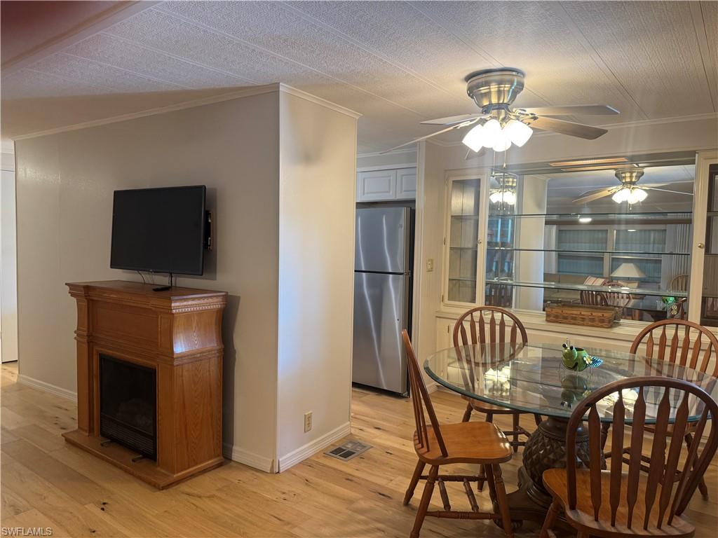 Bright interior featuring wood-finish flooring and a decorative electric fireplace