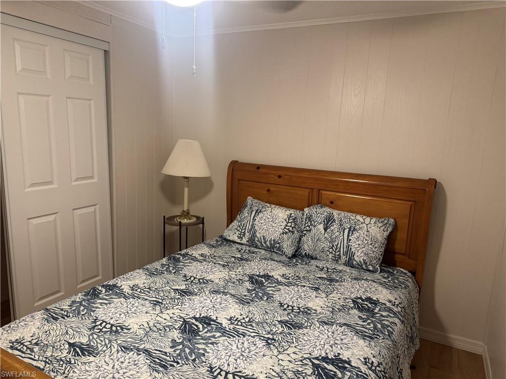 Wood-finish flooring and white paneling define this room, featuring a built-in closet with bi-fold doors