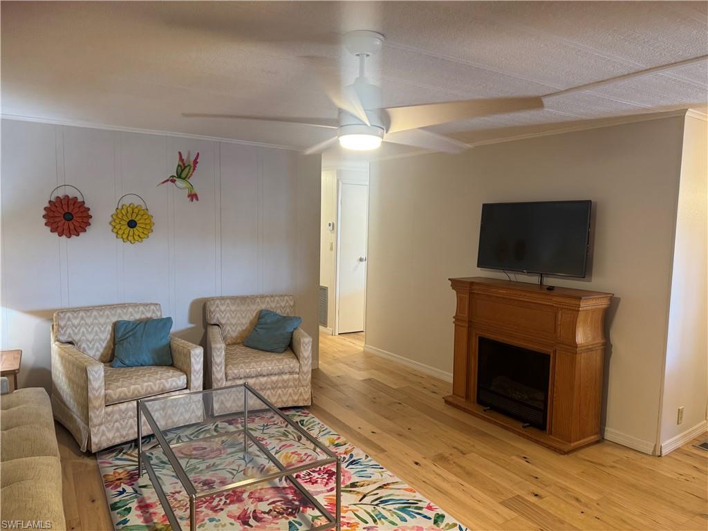 Living area featuring wood-finish flooring and a wood mantel with an electric fireplace