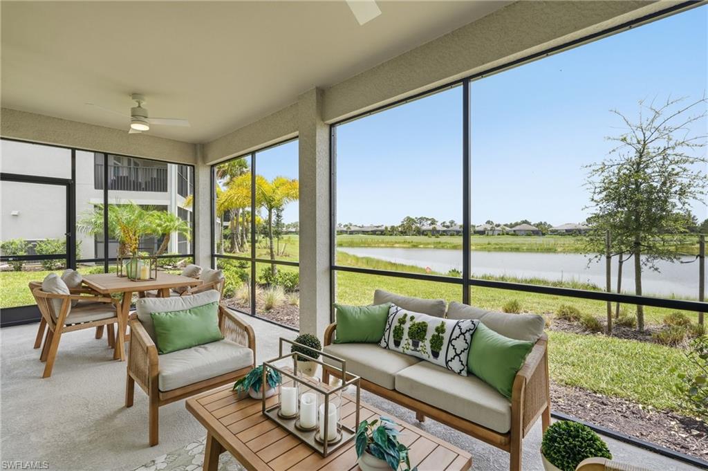 Screened outdoor living area featuring a water body and landscape beyond