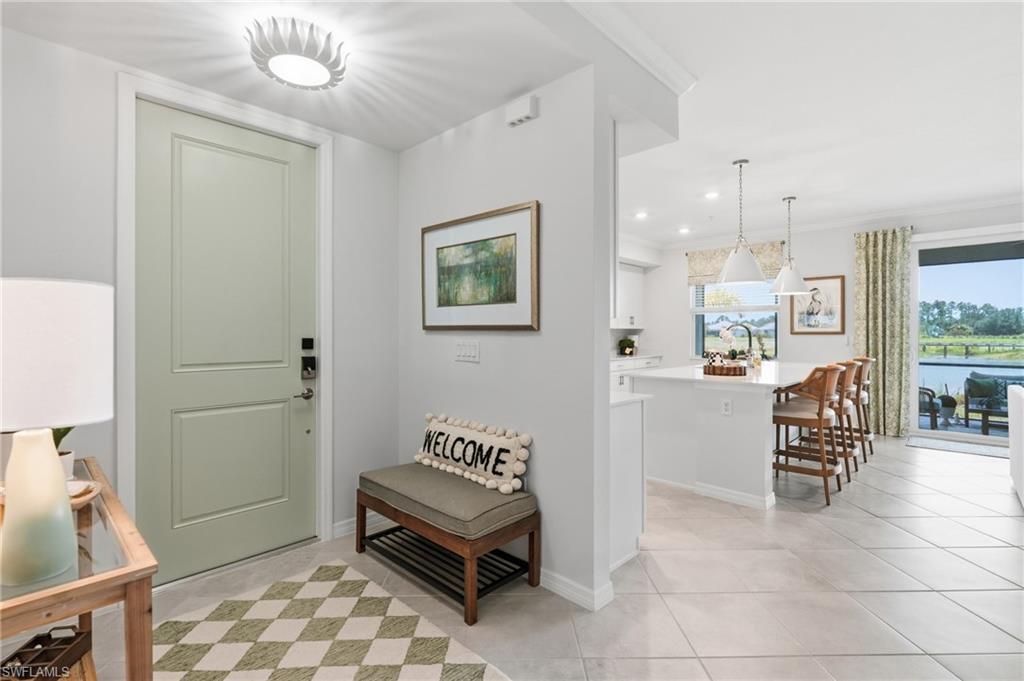Entry foyer with light-toned paneled door, flush-mount ceiling fixture, and tile flooring
