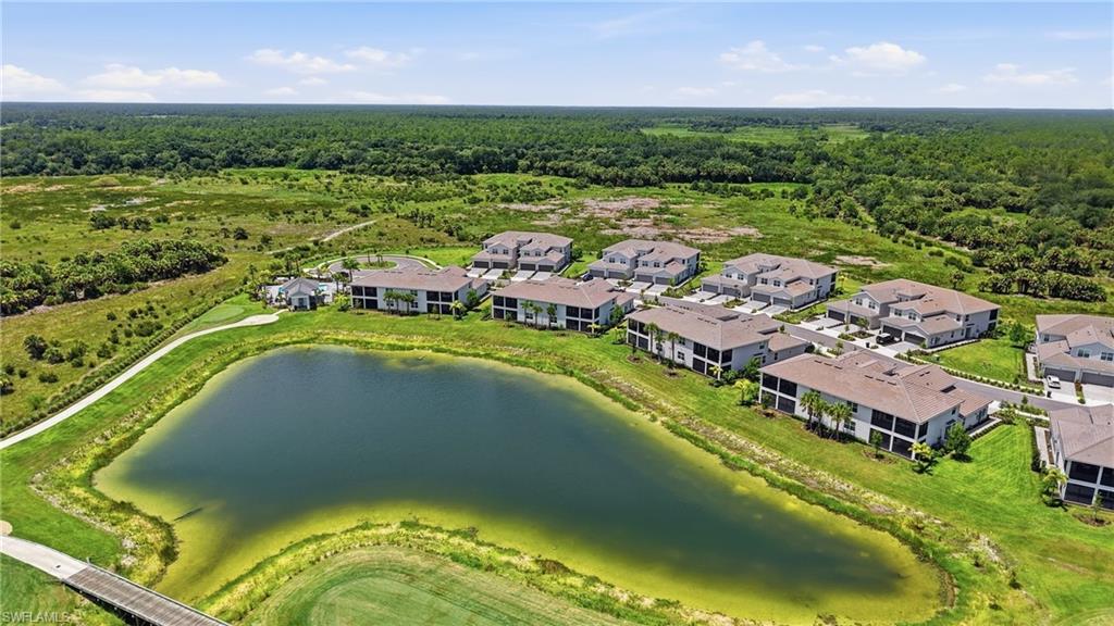 Lakeside community featuring multiple residential buildings with tile roofs and screened balconies