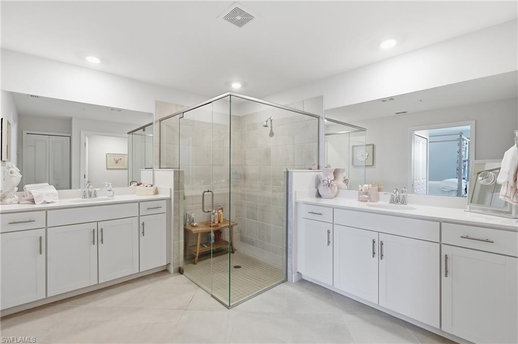 Spacious bathroom featuring a glass-enclosed shower with tiled walls and a tiled floor
