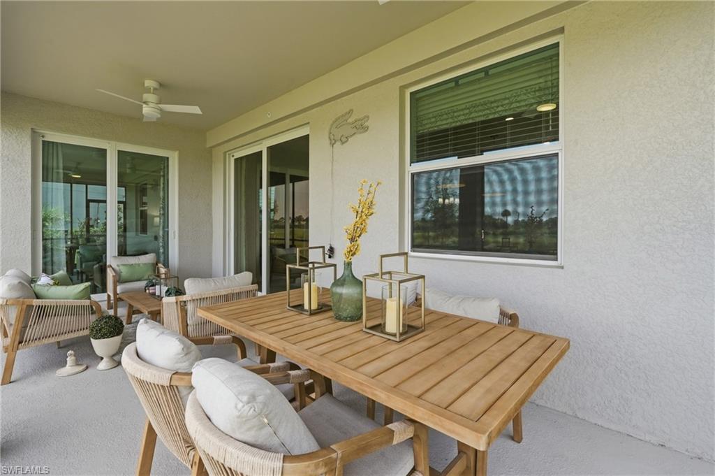 Covered outdoor patio with a ceiling fan, textured exterior wall, and sliding glass doors