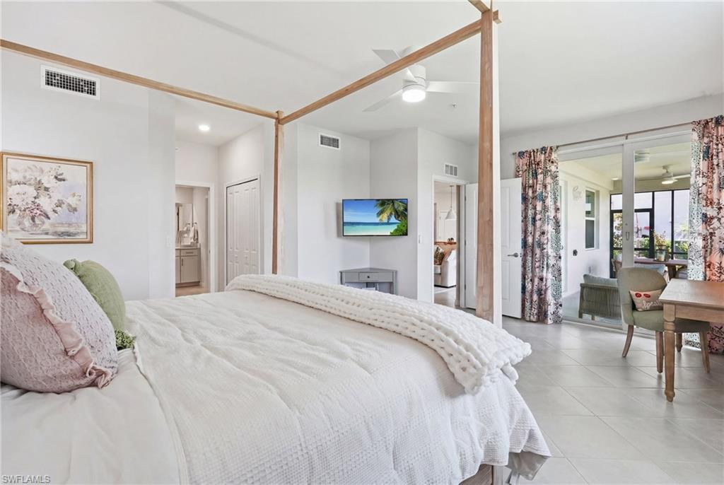 Light-filled bedroom featuring tile flooring, a ceiling fan, and direct access to a private screened balcony through sliding glass doors