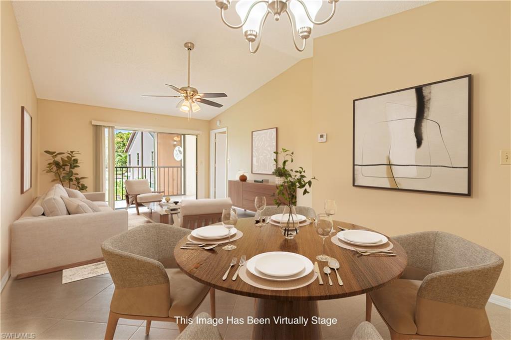 Open-concept living area featuring vaulted ceilings, a ceiling fan, and a large sliding glass door opening to a private balcony