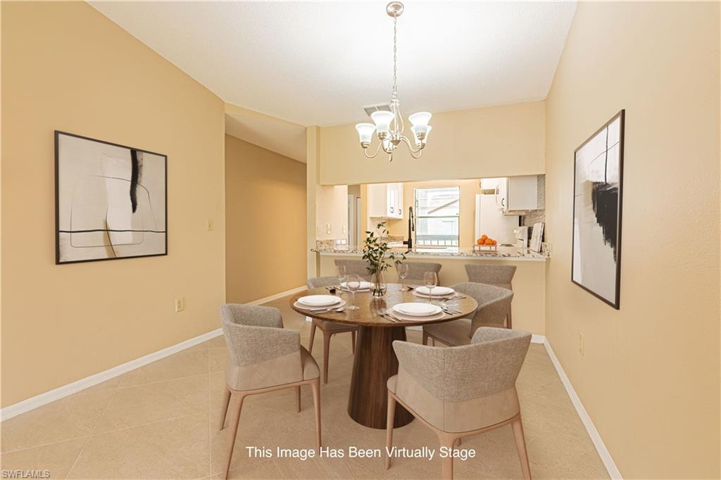 Dining area featuring tile flooring, a chandelier light fixture, and a pass-through opening to the kitchen