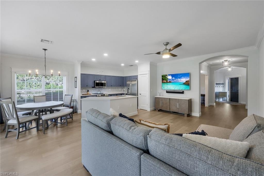 Open-concept living space featuring LVP flooring, recessed lighting, and a ceiling fan