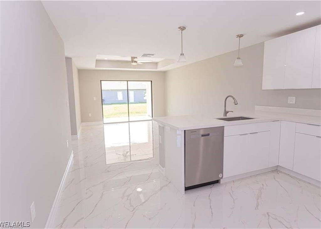 Modern kitchen featuring white cabinetry, a stainless steel dishwasher, and a sink with a gooseneck faucet