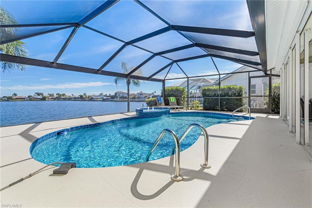 View of swimming pool with glass enclosure, a sunroom, a patio, and a pool with connected hot tub