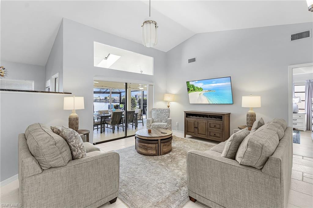 Living area with high vaulted ceiling and baseboards